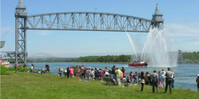 Photograph of Cape Cod Canal Rail Bridge with a crowd of people by the shoreline