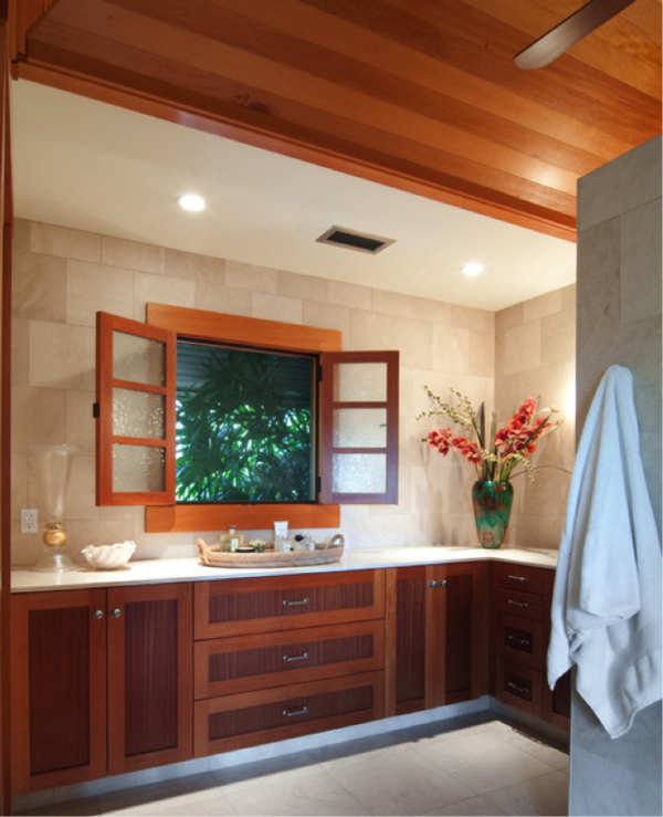photograph of a bathroom with neutral colors and an open window with foliage behind it