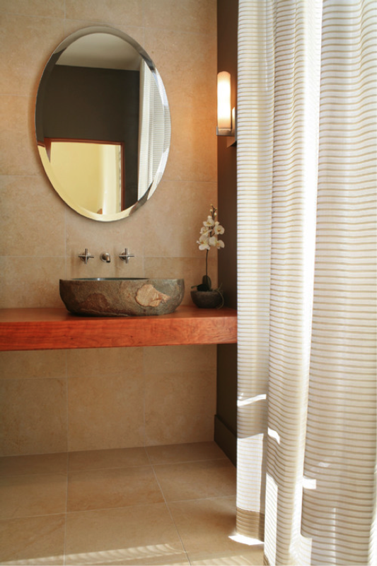 photograph of a bathroom with large bathroom tiles and a mirror