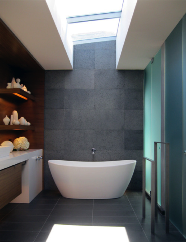photograph of a freestanding bathtub in a bathroom with grey tile