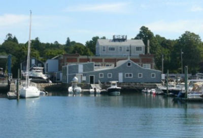 Photograph of South Wharf in Dartmouth that offers transient and permanent slips to boaters in front of a boat house