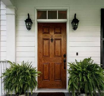 Photograph of a wood Front door of a white home